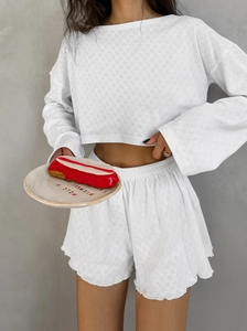 Détail de l'ensemble de détente blanc à motifs de cœurs évidés et bordures ondulées