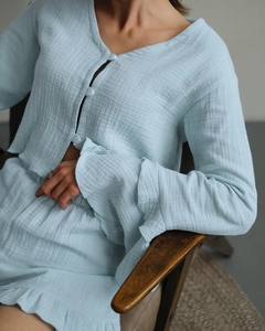 Detail of light blue cotton pajamas showing ruffled cuffs and textured breathable fabric