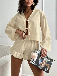 Detail of ruffled hem shorts and tie-front long sleeve loungewear set in cream beige