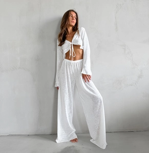 Detail of white long sleeve cropped cardigan and high waisted wide leg trousers set