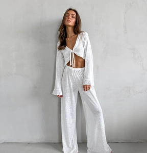 Detail of white two-piece loungewear featuring a V-neck tie-front top and wide-leg pants
