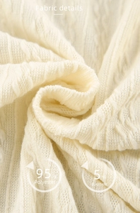 Detail of cream cable knit fabric showing 95% polyester and 5% elastane texture