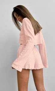 Détail de la texture de l'ensemble court rose avec motif jacquard à cœurs et short