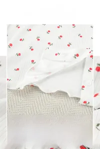 Detail of ribbed knit pajamas with red rose print and wavy lettuce edge hem finishing