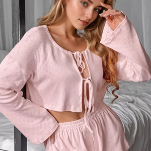 Women's light pink knitted loungewear set featuring long sleeve tie-front top and shorts