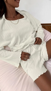 Detail view of white pointelle knit lounge set with elegant ruffled edges and textures