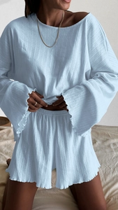 Detail of light blue pointelle knit pajamas with lettuce edge trim and soft texture