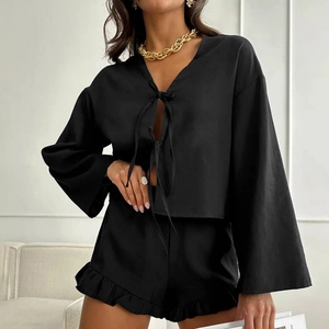 Women's black lounge set featuring tie-front cardigan and ruffled shorts in a loose fit