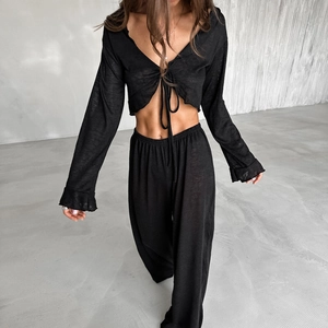 Women's two-piece black knit lounge set with long sleeve tie-up top and wide leg pants