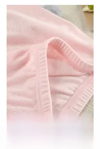 Close-up of pink knitted jacquard fabric with delicate heart cutouts and neat stitching