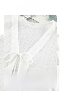 Close-up of white镂空knit pajama top with ruffle V-neckline and delicate bow tie detail