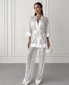 Detail of white lace kimono top and wide-leg trousers set with silk satin trim