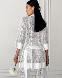 Detail of floral lace texture and satin trim on white two-piece loungewear set