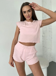 Close-up of pink knit pajama set featuring textured jacquard fabric and ruffled lettuce edges