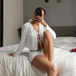 Detail of white ribbed knit pajama set with delicate ruffle trim and tie-front closure