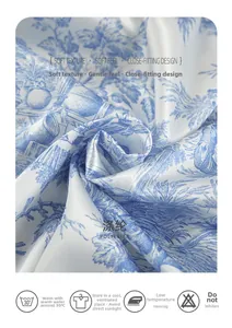 Close-up of blue floral satin polyester fabric texture and care instructions label