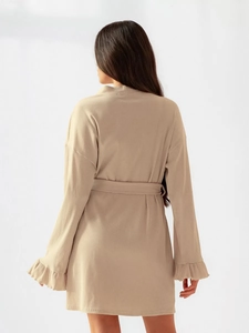 Detail of ribbed knit beige sleepwear showing ruffled cuffs and belted waist design