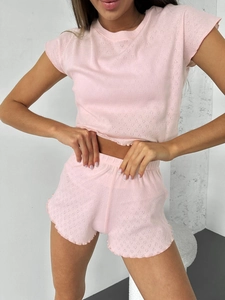 Detail of pink knit pajama set showing hollow diamond pattern and lettuce edge hems