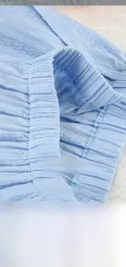 Détail du tissu plissé bleu clair avec taille élastique et travail de couture