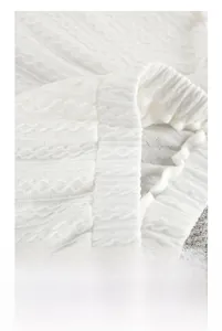 Close-up of white knit loungewear showing detailed cable stitch pattern and ribbed hem texture
