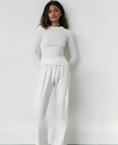 Détail d'un ensemble de pyjama blanc en maille côtelée avec bordure ondulée sur le haut à manches