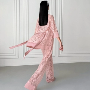 Pink lace two-piece pajama set featuring lace robe with tie waist and wide-leg trousers