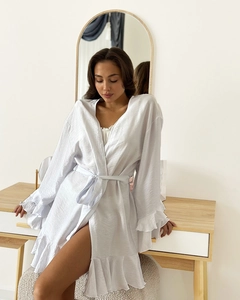Detail of white satin robe featuring elegant ruffled sleeves and a matching waist tie