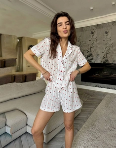 Close-up of women's cotton pajama set with red heart patterns and fine vertical stripes