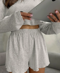 Close-up of light gray pointelle knit loungewear set with ruffle hem shorts and crop top