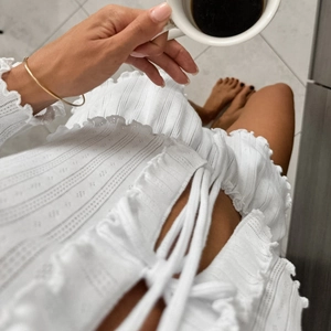 White pointelle knit pajama set with ruffled edges and lace-up top for women