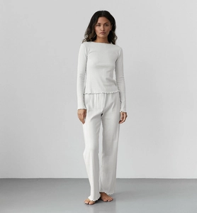 Détail d'un pyjama en maille montrant la texture côtelée et les bords ondulés délicats