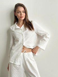 Detail eines weißen Baumwoll-Pyjama-Sets mit vertikalen Streifen und Kordelzug am Bund