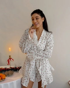 Détail des bords à volants et de l'imprimé floral sur l'ensemble pyjama en coton blanc