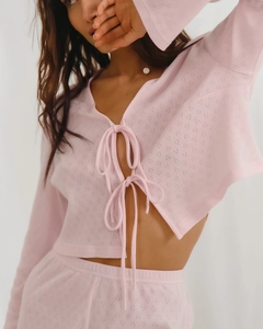 Gros plan sur le tricot ajouré à cœurs roses avec rubans noués délicats devant