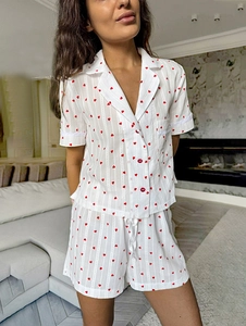 Close-up of heart print cotton pajamas with lace cuffs and red button details