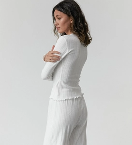 Détail du pyjama blanc en tricot avec découpes en cœur et bordures volantées délicates