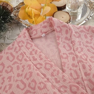 Close-up of pink leopard print cotton bathrobe fabric texture and V-neckline detail