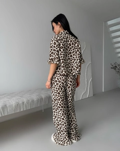 Detail of leopard print pajama set featuring ruffle sleeve cuffs and textured beige fabric