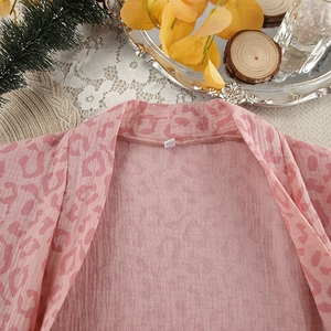 Detailed macro view of pink leopard print bathrobe fabric with distinct pleated texture