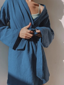 Detail of soft dark blue cotton bathrobe showing the tie-belt and wrinkled gauze texture