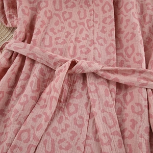 Close-up of pink leopard print cotton bathrobe showing the tie belt and fabric texture