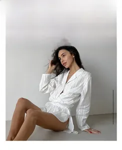 Detail of white striped cotton pajama set with long sleeve button-up top and matching shorts