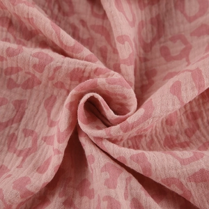 Close-up of pink leopard print bathrobe fabric with soft crinkle texture and cotton gauze