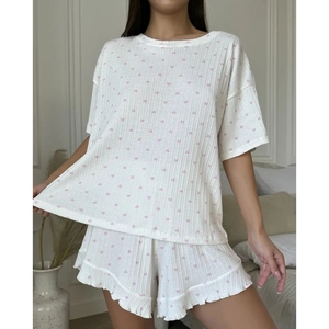 Detail of white ribbed knit pajama set with pink heart prints and ruffled hem shorts