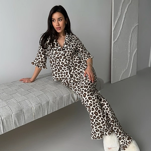 Women leopard print pajama set with ruffle trim top and pants in a cozy indoor setting