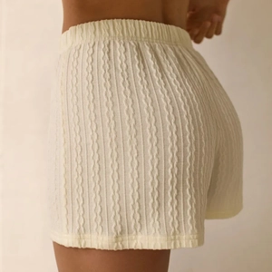 Detailansicht der cremefarbenen Strickshorts mit Zopfmuster und elastischem Bund