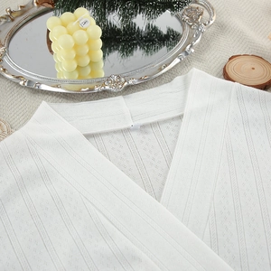 Detail of white knit cardigan fabric with delicate hollow pointelle and vertical ribbing texture