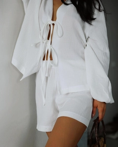 Detail of white crepe two-piece pajama set featuring front ties and textured fabric