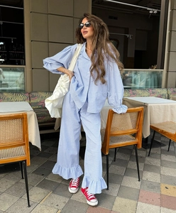 Close-up of blue gingham loungewear set featuring ruffle trim and button-down detail