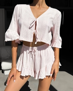 Detailed view of pink knitted loungewear set featuring ruffle trim and textured fabric